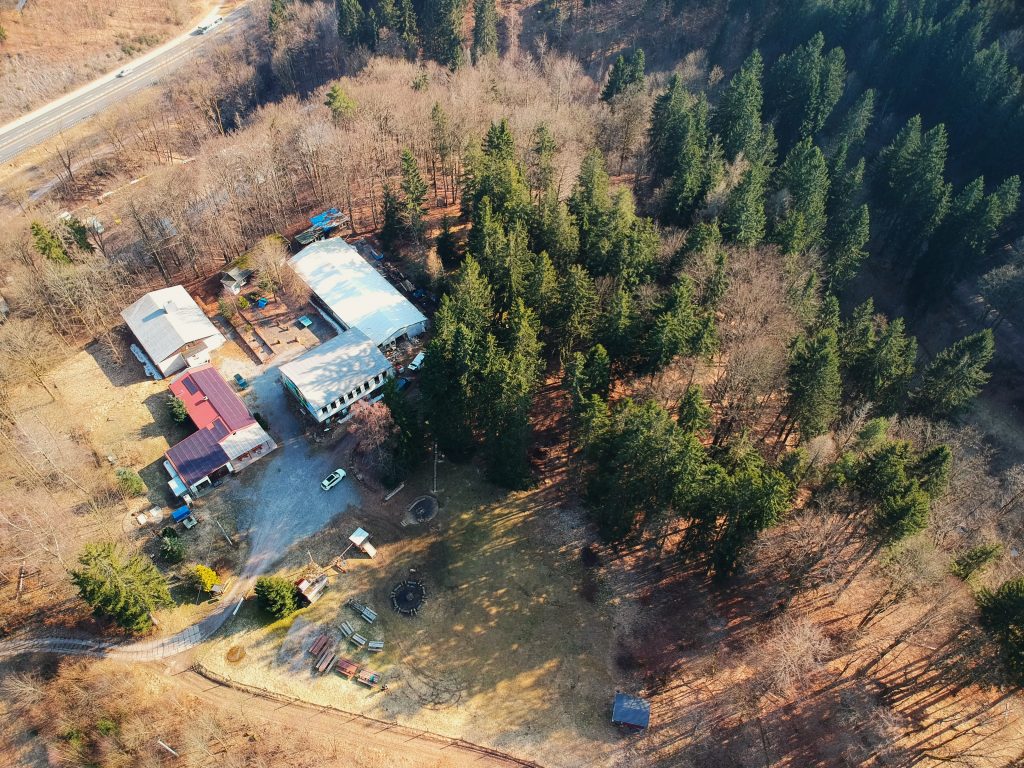 Erlebnis-Werk Gelände von oben fotografiert, mehrere Gebäude und Wald drumherum 